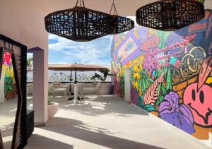 普拉亚卡门Auténtico Vertical Playa del Carmen的墙上挂着带桌子和雨伞的画作