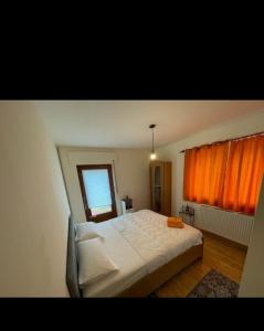 FreirachdorfOsteria Mediterranean的卧室配有白色的床和橙色窗帘