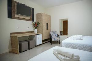 坎布里卡姆布里普拉亚酒店的客房设有两张床、一张桌子和一台电视机。