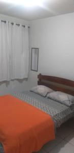 新弗里堡Pousada Serra Carioca Friburgo的一间卧室配有一张带橙色毯子的床