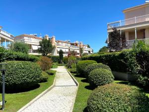 罗马Ada’s Garden House的一座花园,花园内有灌木丛和一条小径,位于一座建筑前