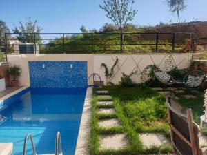 地拉那Stylish two bedroom house with private pool的后院设有游泳池和花园