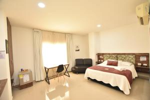 蒙特里亚Hotel La Casa N. 3的卧室配有床、椅子和窗户。