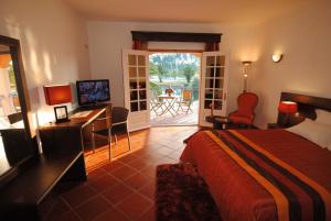 普拉亚德米拉海尔达德拉戈雷尔酒店的酒店客房设有一张床、一张书桌和一个阳台。