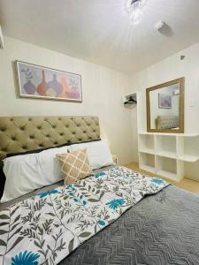 伊洛伊洛Spacious 2 bedroom 42sqm condo unit的一间卧室配有一张大床和大床头板