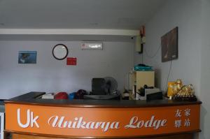 哥打京那巴鲁Unikarya Lodge的大使馆大厅,柜台上有一个标志