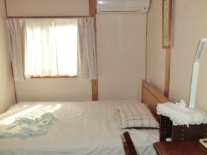 武藏野交流の宿的一间小卧室,配有床和窗户