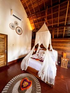 珀尼达岛Griyatama Bungalow的一间卧室配有一张带蚊帐的床