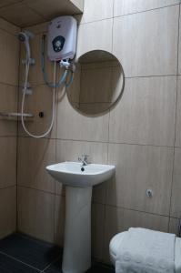 哥打京那巴鲁Unikarya Lodge的一间带水槽、镜子和卫生间的浴室