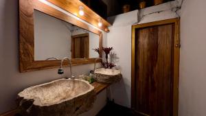 贝都古Chakra Tavern的一间带大型石质水槽和镜子的浴室
