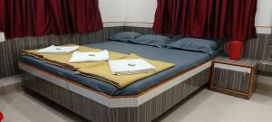 舍地Sai Raghunandan Guest House的床上铺有白色毛巾的床