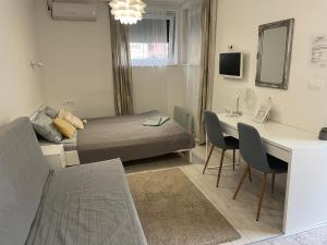豪伊杜索博斯洛Sunrise Apartment的小房间设有一张床和一张带椅子的桌子