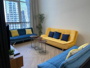 阿布扎比Elite Private Residential Apartment in a Prime Location Al Reem Island - 1301的客厅配有黄色沙发和蓝色枕头