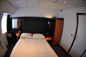 米德尔堡美丽河滨酒店的一间卧室配有一张大床和黑色床头板