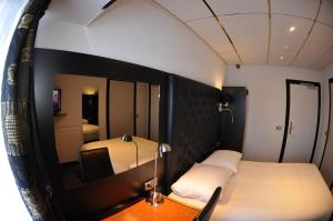 米德尔堡美丽河滨酒店的小房间设有床和镜子