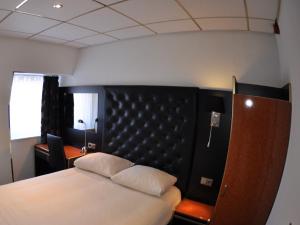 米德尔堡美丽河滨酒店的一间卧室配有一张带黑色床头板的床