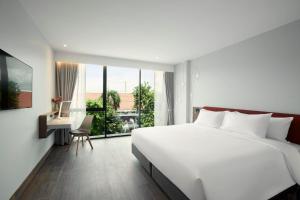 曼谷Centara Life Hotel Bangkok Phra Nakhon的卧室配有一张白色大床和一张书桌