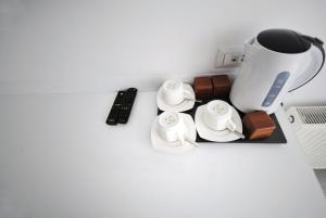 普里什蒂纳Hotel Callisto的一张桌子、咖啡壶和遥控器