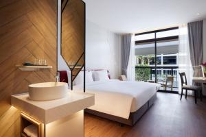 曼谷Centara Life Hotel Bangkok Phra Nakhon的酒店客房设有一张大床和一个水槽