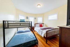 波士顿90-Boston Spacious Convenient Apartment的一间带两张双层床和电视的卧室
