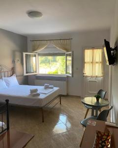 安吉斯特隆Guesthouse Anestis的一间卧室设有一张床、一个窗口和一张桌子