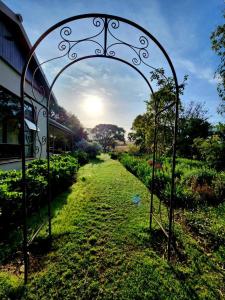 里弗斯代尔Lalani B&B/Self catering Cottages的通往带田野的花园的开放式大门