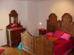 FannaB&B Castellani的卧室配有带粉红色枕头的大型木质床