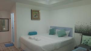 班佩Pon Resort的一间卧室配有白色的床和绿色和蓝色的枕头