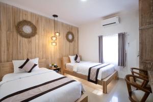 库塔Oki Taru Residence的酒店客房设有两张床和窗户。
