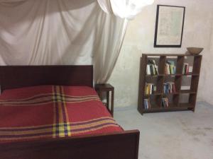 莫桑比克岛Casa Fabula的一间卧室配有床和书架