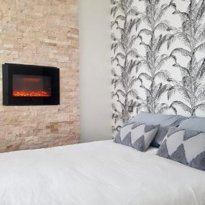 萨尔格米纳Studio calme-équipements haut de gamme的卧室配有1张白色床和壁炉