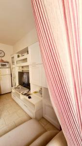 比萨Pisa City Home B&B的厨房配有白色橱柜和窗帘