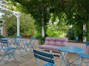 库特罗菲安诺I fichi bianchi的紫色沙发,坐在树下,配有桌椅