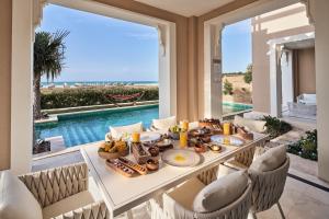 阿布扎比Rixos Premium Saadiyat Island - All Inclusive的一间用餐室,配有一张带食物的桌子,享有海景