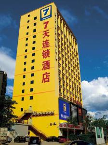 毕节7天连锁酒店毕节东客站店的黄色建筑的侧面