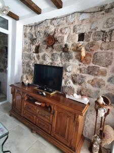布德瓦Stone house Djakonovic的木柜上的电视,放在石墙里