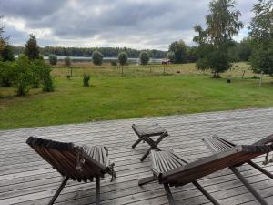 拉塞博里Holiday Cottage Tiira的木甲板上设有两张木凳子,甲板上设有田野