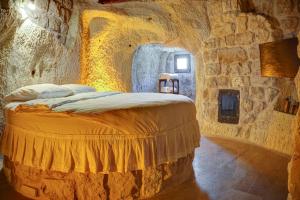 内夫谢希尔Saliche Cave Suite的石头间内一间卧室,配有一张床