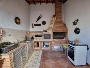 伊塔尼亚恩Hostel Pé na Areia的一间带炉灶和壁炉的厨房