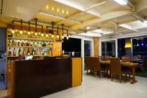 甘托克Mann Dechen and Palmo, Mg Marg, Gangtok的餐厅设有酒吧,配有桌椅