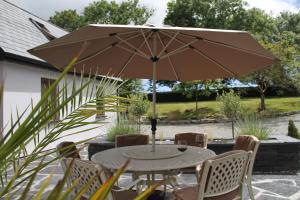 斯奇博瑞恩Boatman's Quarters的庭院内桌椅和遮阳伞