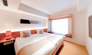 京都HOTEL RINGS KYOTO的一间卧室设有一张大床和一个大窗户