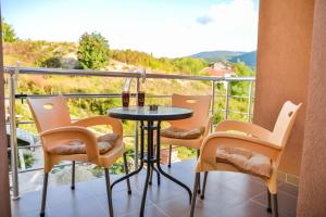 索科矿泉村Apartmani Milenkovic的设有一个配有桌椅并享有美景的阳台。