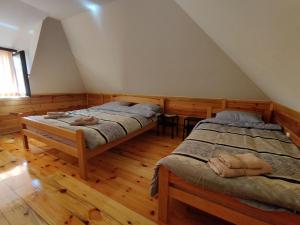 ZaovineMilijin konak的铺有木地板的客房内的两张床
