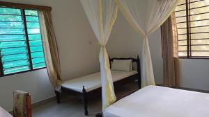 基利菲Makuti Villas Resort的一间卧室设有两张床和两个窗户。
