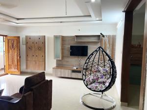 蒂鲁帕蒂Ameya Homestays Brand New Fully Furnished 3BHK & 2BHK Apartments.的客厅配有椅子和秋千