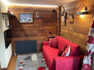 布勒伊-切尔维尼亚Baita del Cervino CIR n 0016的配有木墙的客房内的红色沙发