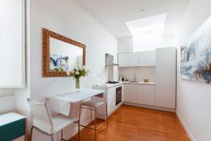 坎波巴索Cobalto Suite的厨房配有白色橱柜和桌椅