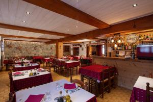 布齐耶比利牛斯2000Logis Hôtel Restaurant L'ancienne Auberge的一间带桌椅的餐厅和一间酒吧