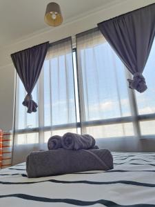 巴特沃思Woodsbury Suites IKEA House Butterworth Penang的窗户上的一张带两条毛巾的床